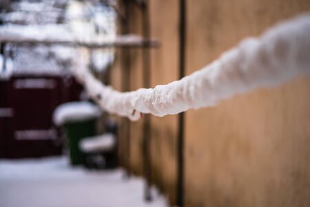 Wire fence and metallic net with snow. Metal net in winter covered with snow.の写真素材