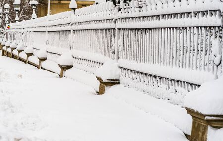 Metallic fence with snow. Metal fence in winter covered with snow. 
Snowy environment in the morningの写真素材