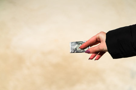 Woman hand holding and giving money. World money concept, close up of USD banknote, photo of...