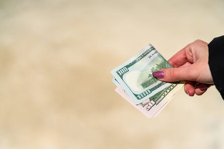 Woman hand holding and giving money. World money concept, close up of USD banknote, photo of...