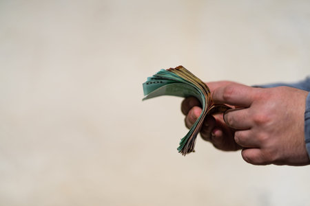 Man hand counting money for a bribe or tips. Holding EURO banknotes on a blurred background, EURO...