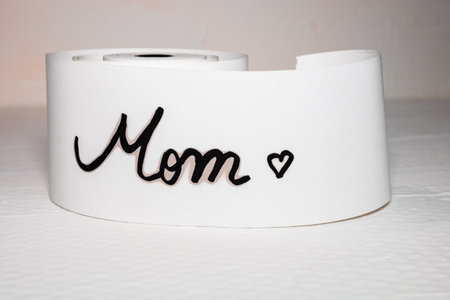 Mom writing love text for mother on paper. Label tag with lovely message for mother`s day.