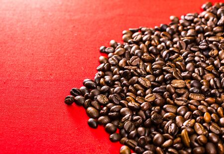 Roasted coffee beans on red background, top view, copy space for text, coffee conceptの写真素材
