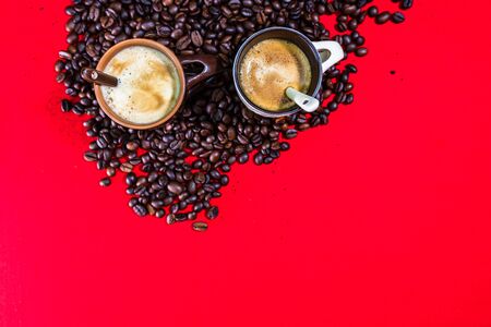Cup of coffee, roasted coffee beans on red background, top view, copy space for text, coffee concept, close up coffee photoの写真素材