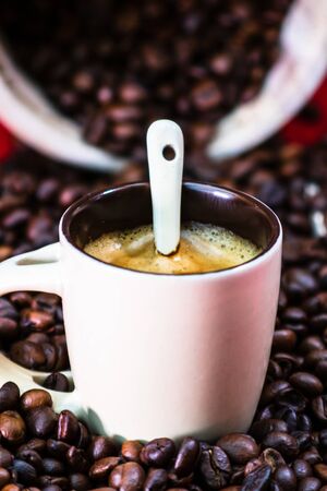 Close up of cup of coffee, roasted coffee beans on red background, coffee concept, close up coffee photoの写真素材