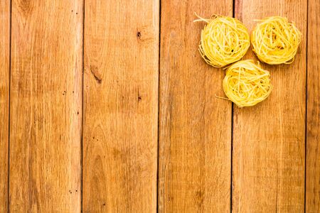 Detail view of macaroni and pasta on wooden background, top view, copy space for text, close up photoの写真素材
