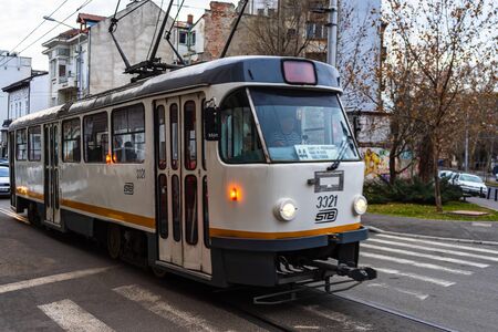Car traffic and old tramway on the tracks at rush hour in downtown area of the city. Car pollution, traffic jam in the morning and evening in the capital city of Bucharest, Romania, 2020のeditorial素材