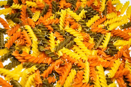 Composition of raw pasta uncooked tricolore fusilli, pasta twist shape. Close up and selective focus on colorful fusilli pasta.の写真素材