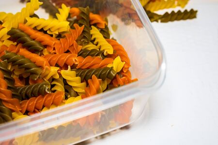 Composition of raw pasta uncooked tricolore fusilli, pasta twist shape. Close up and selective focus on colorful fusilli pasta.の写真素材
