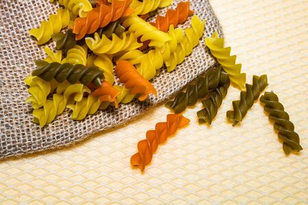 Composition of raw pasta uncooked tricolore fusilli, pasta twist shape. Close up and selective focus on colorful fusilli pasta.の写真素材