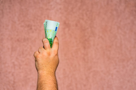 Hand holding showing euro money or giving money like bribe or tips.100 EURO banknotes EUR currency...
