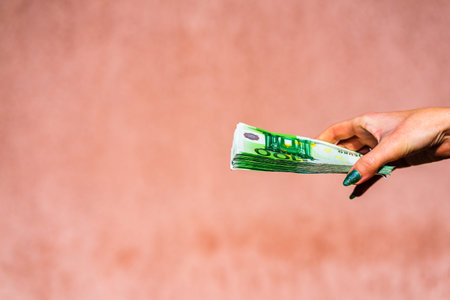 Hand holding showing euro money or giving money like bribe or tips.100 EURO banknotes EUR currency...