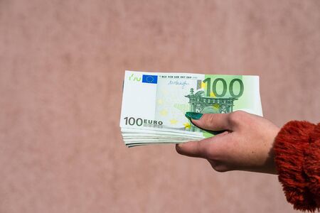 Hand holding and showing euro money or giving money. World money concept, 100 EURO banknotes EUR currency isolated. Concept of rich business people, saving or spending money.の写真素材