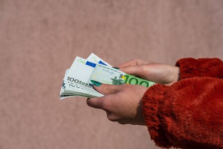 Hand holding and showing euro money or giving money. World money concept, 100 EURO banknotes EUR currency isolated. Concept of rich business people, saving or spending money.の写真素材