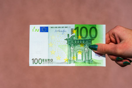 Hand holding and showing euro money or giving money. World money concept, 100 EURO banknotes EUR...