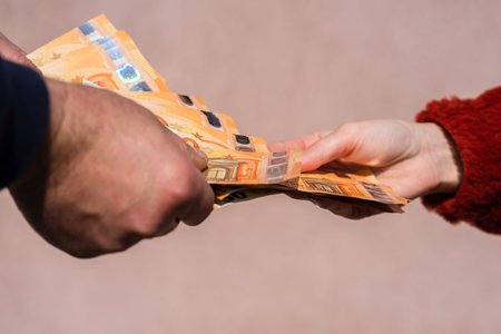 Hand giving money like bribe or tips or salary isolated, hard worked hand taking euro banknotes....