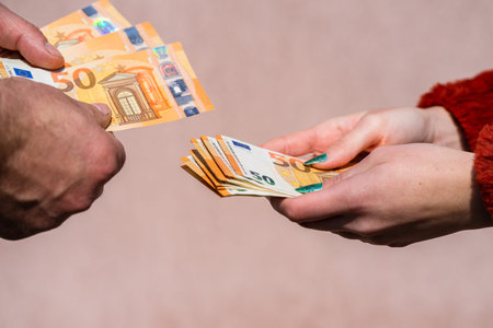 Hand giving money like bribe or tips or salary isolated, hard worked hand taking euro banknotes....
