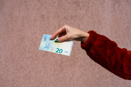Hand holding showing euro money and giving or receiving money like tips, salary. 20 EURO banknotes EUR currency isolated. Concept of rich business people, saving or spending money.の写真素材