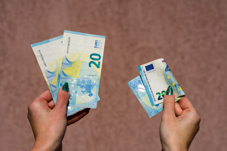 Hand holding showing euro money and giving or receiving money like tips, salary. 20 EURO banknotes...