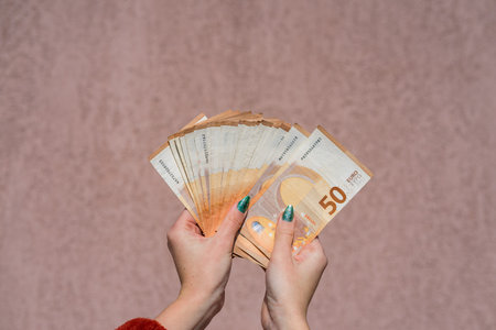 Hand holding and showing a fan of euro money or giving money. World money concept, 50 EURO banknotes EUR currency isolated. Concept of rich business people, saving or spending money.の写真素材