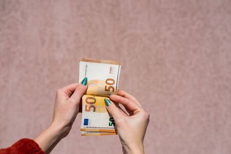 Hand couting holding and showing euro money or giving money. World money concept, 50 EURO banknotes EUR currency isolated with copy space. Concept of rich business people, saving or spending money.の写真素材