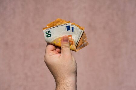Hand holding and showing a fan of euro money or giving money. World money concept, 50 EURO banknotes EUR currency isolated. Concept of rich business people, saving or spending money.の写真素材