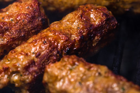 Traditional Romanian food Meat Balls mici on grill. Tasty meat balls on barbeque, pork meat on...