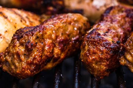 Traditional Romanian food Meat Balls "mici" on grill. Tasty meat balls on barbeque, pork meat on charcoal barbecueの写真素材