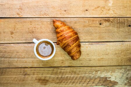 Fresh croissant, puff pastry and biscuits on wooden table. Coffee, food and breakfast concept. Desserts, fresh pastries and coffee. Top view and copy spaceの写真素材