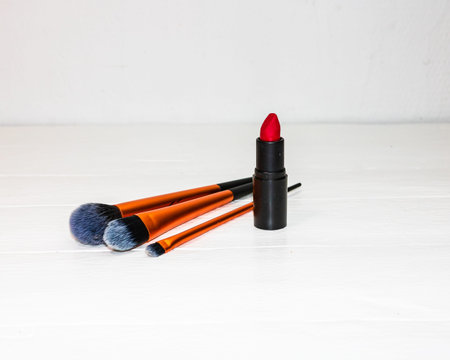 Red lipstick and make up brushes isolated on white background with copy space.の写真素材