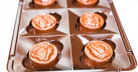 Variety of delicious chocolate pralines in box. Close up of bonbons isolated on white, selective focus.の写真素材