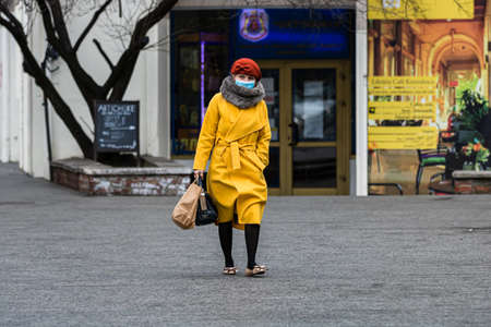 Covid-19 flu disease virus spreading in Europe. People wearing medical mask against coronavirus, influenza viruses and diseases. Healthcare concept. Woman wearing surgical mask on face in public spaces in Bucharest, Romania, 2020のeditorial素材