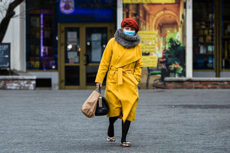 Covid-19 flu disease virus spreading in Europe. People wearing medical mask against coronavirus, influenza viruses and diseases. Healthcare concept. Woman wearing surgical mask on face in public spaces in Bucharest, Romania, 2020のeditorial素材