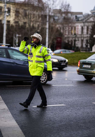 Police agent, Romanian Traffic Police (Politia Rutiera) directing traffic during the morning or evening rush hour in downtown Bucharest, Romania, 2020のeditorial素材