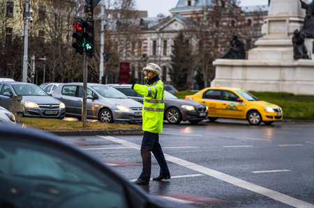 Police agent, Romanian Traffic Police (Politia Rutiera) directing traffic during the morning or evening rush hour in downtown Bucharest, Romania, 2020のeditorial素材