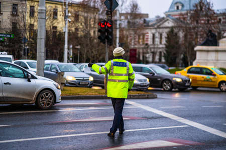 Police agent, Romanian Traffic Police (Politia Rutiera) directing traffic during the morning or evening rush hour in downtown Bucharest, Romania, 2020のeditorial素材