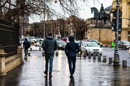 Photo from behind of people walking on a rainy day on the main boulevard of Bucharest city, Romania 2020のeditorial素材