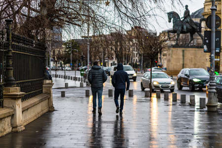 Photo from behind of people walking on a rainy day on the main boulevard of Bucharest city, Romania 2020のeditorial素材