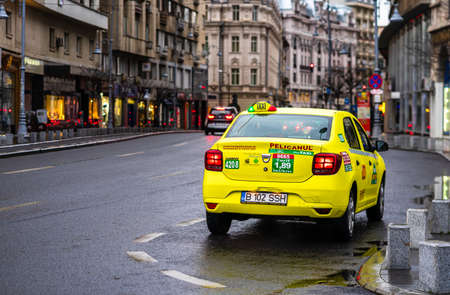 Detail photo of a taxi, in a rainy day,  parked on the main boulevard of Bucharest city, Romania, 2020のeditorial素材
