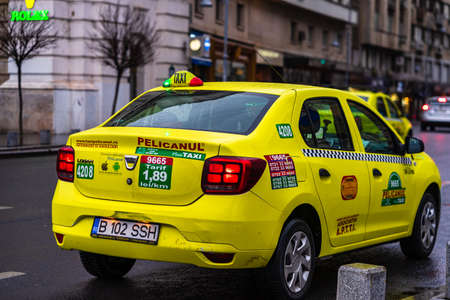 Detail photo of a taxi, in a rainy day,  parked on the main boulevard of Bucharest city, Romania, 2020のeditorial素材