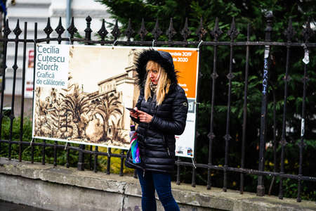 Blonde woman using her touchscreen phone in the city of Bucharest, Romania, 2020のeditorial素材