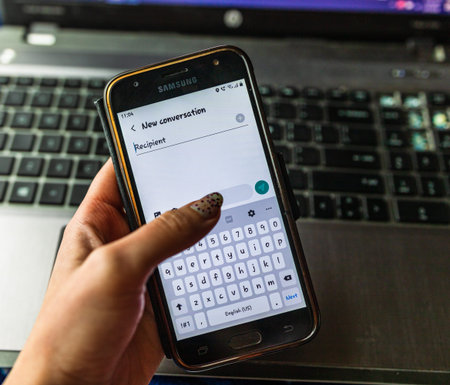 Messages application, start a new conversation on smartphone screen pixelated close up view.  Hand...