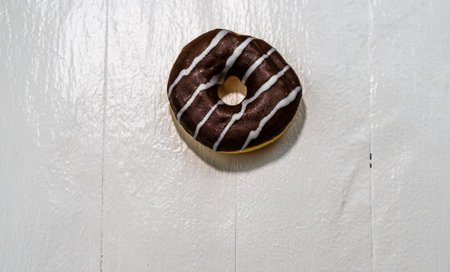 Colorful donuts on white wooden table. Sweet icing sugar food with glazed sprinkles, doughnut with...