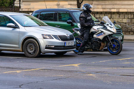 Force one security division services motorcycle in traffic waiting at traffic light in downtown of Bucharest, Romania, 2020.のeditorial素材