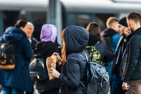 Travelers and commuters carry luggage and backpacks on the train platform of Bucharest North Railway...