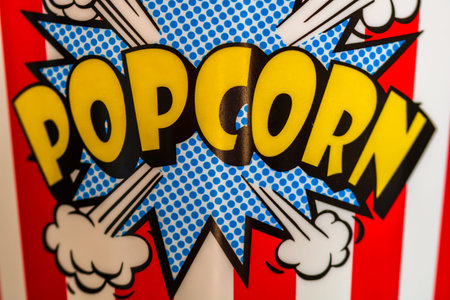 Plastic container for popcorn isolated close up photo. Popcorn sign on plastic and empty red and...