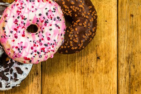 Colorful donuts on table with copy space. Top view of glazed doughnuts isolated.の写真素材