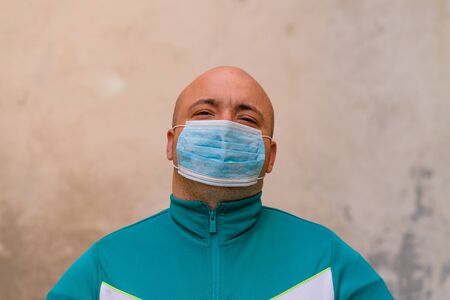 Sick young man with medical face mask portrait close up illustrates pandemic coronavirus disease on blurred background. Covid-19 outbreak contamination conceptの写真素材