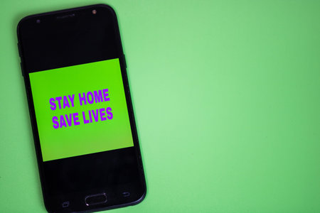 Stay home, save lives writing on the screen of a smartphone. Medical protective equipment isolated....
