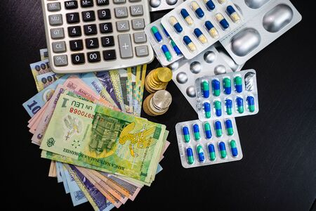 World money concept, Romanian LEI currency with calculator and medicine on black table. Inflation due to the Coronavirus epidemyの写真素材